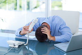 Frustrated project manager with his head on his desk.